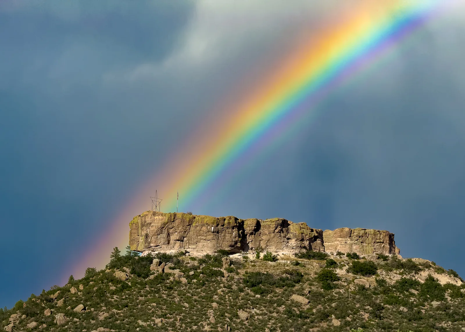 The Castle Rock butte under a stormy sky with a rainbow
