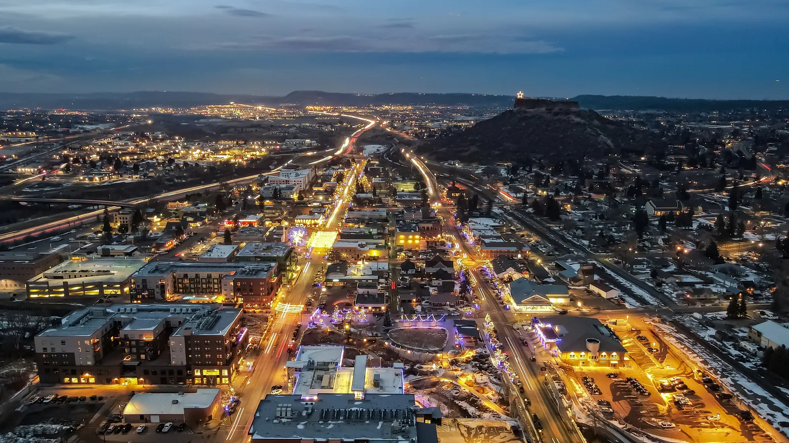 Aerial view of downtown Castle Rock Colorado at dusk with holiday lights along Wilcox Street and the lit star on Castle Rock bluff