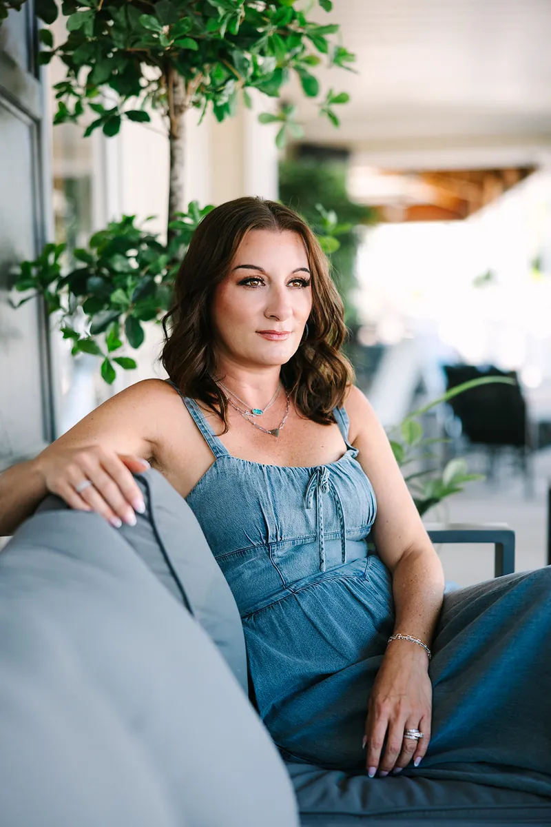 Jessica Lentz relaxing on a patio sofa surrounded by greenery