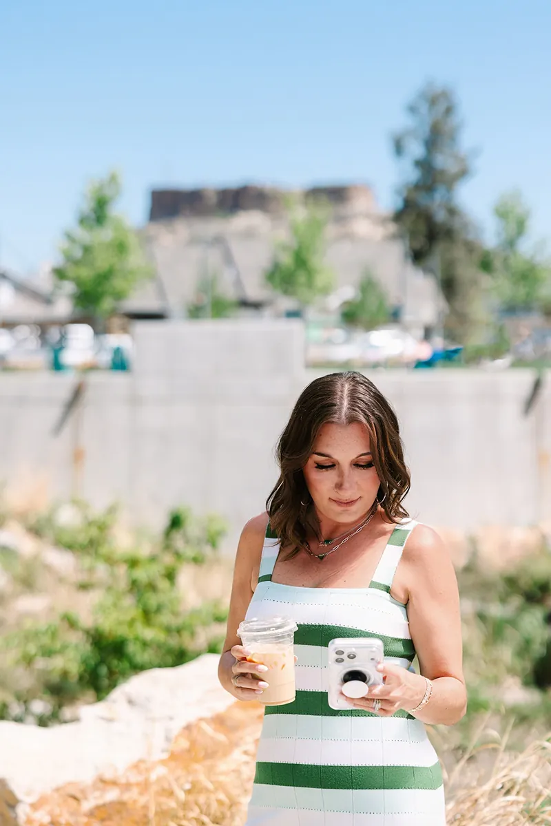 Jessica Lentz with an iced coffee in front of the Castle Rock butte