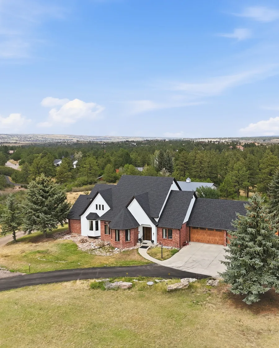 Brick and white home on an acreage lot surrounded by pines in Franktown, one of Jessica's listings